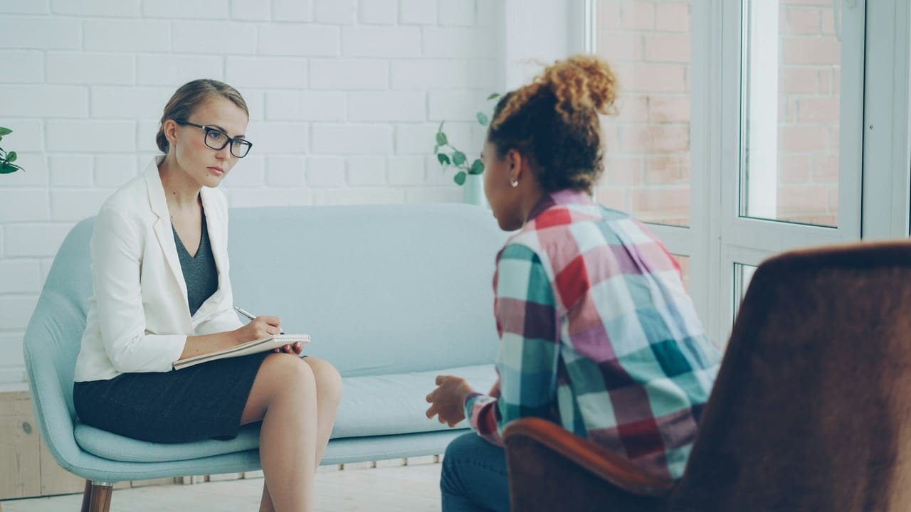A therapist listening to a client in a bright room
